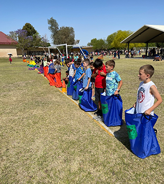 Students outside getting ready for a sack race
