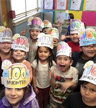 Group of young students wearing 100 day celebration paper hats