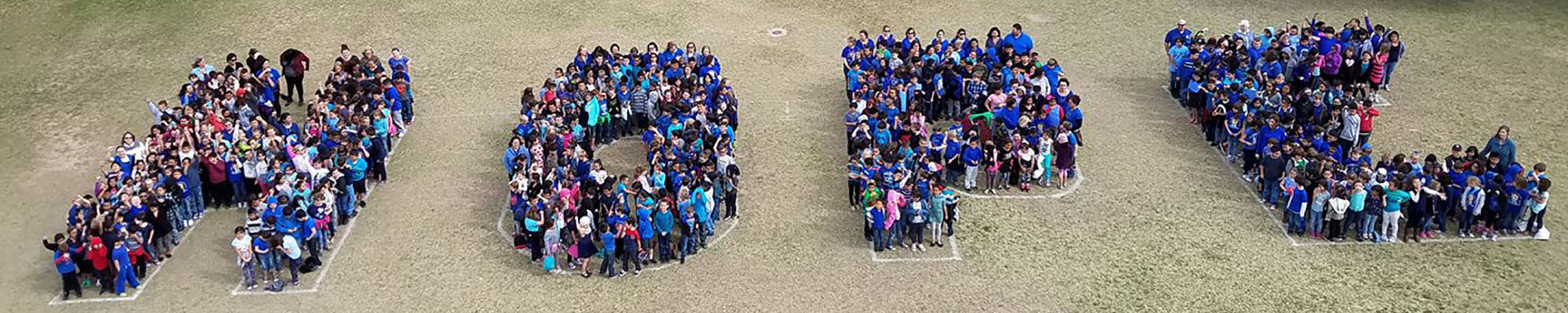 Students stand together outside to form the word hope